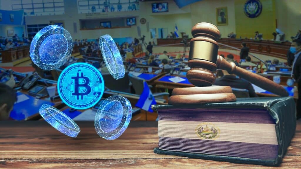 moneda bitcoin entre monedas digitales junto al libro de leyes con bandera de El Salvador y mazo de juez, con asamblea legislativa al fondo